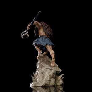 A back view of the Vultureman statue, showcasing the detailed brown fur on his back and the tattered blue skirt.