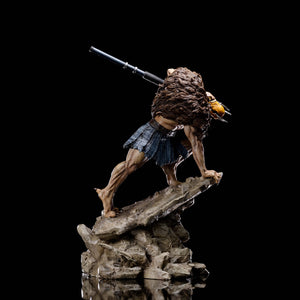 A right profile of the Vultureman statue, emphasizing the muscular details of his legs and the rocky terrain of the base.