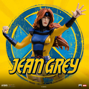 A dramatic, stylized image of the Jean Grey statue against a yellow and blue X-Men logo background, highlighting her pose and uniform.