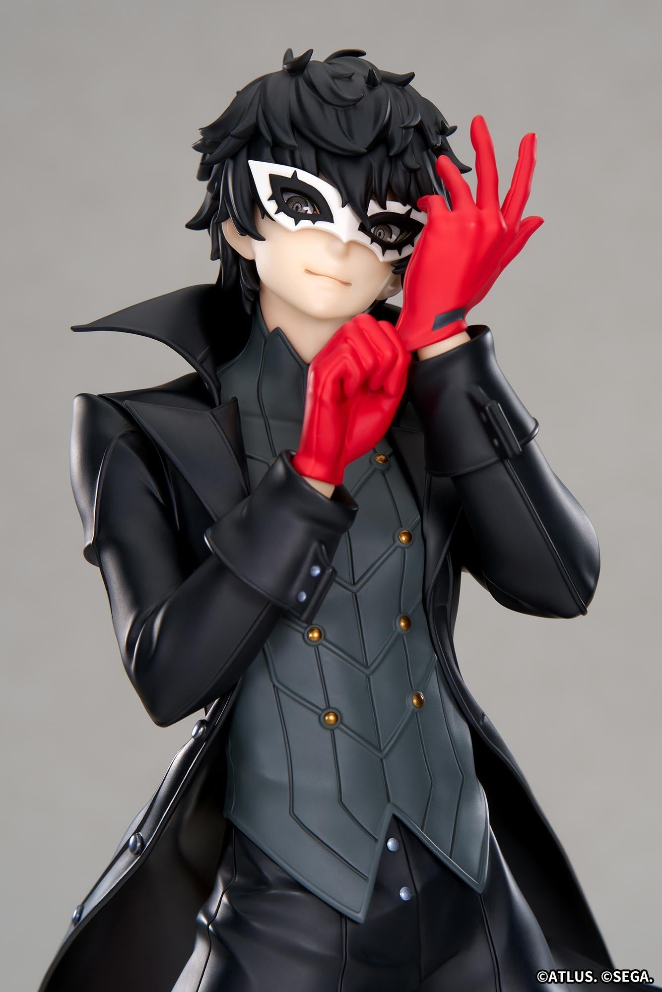 Close-up portrait view of the Joker scale figure focusing on his detailed white bird mask, confident smirk, messy black hair, and bright red gloves.