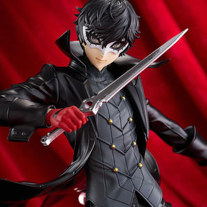 Close-up cinematic shot of the Joker figure wearing his mask and red gloves, posed against a dramatic red draped background.