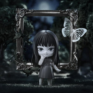 Cinematic lifestyle display of Tomie Nendoroid in a dark forest setting with a picture frame and paper butterfly.