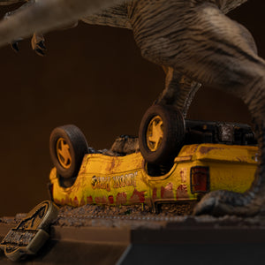 Close-up macro view of the overturned yellow and green Jurassic Park tour vehicle component, showing realistic mud splatters, weathering, and blood-like rust detailing under the T-Rex's weight.