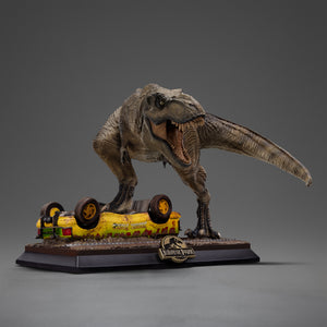 Three-quarter studio view of the hand-painted T-Rex Attack mini statue from Jurassic Park by Iron Studios, showcasing the realistic skin texture, anatomy, and stylized logo base.
