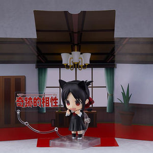 Kaguya Shinomiya Nendoroid wearing cat ears with a panicked, excited blushing face plate, displayed in front of the cardboard student council room background sheet and a "Miraculous Compatibility" text plate.
