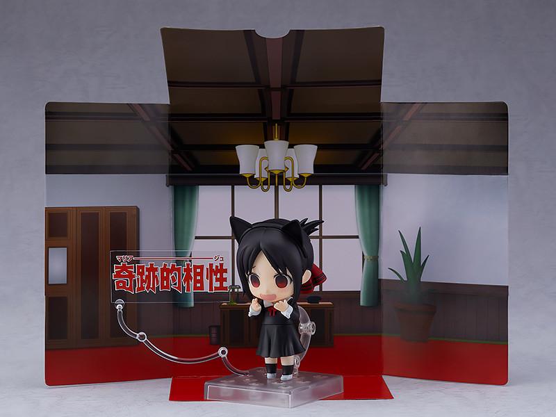 Kaguya Shinomiya Nendoroid wearing cat ears with a panicked, excited blushing face plate, displayed in front of the cardboard student council room background sheet and a "Miraculous Compatibility" text plate.