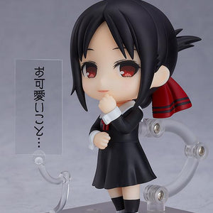 Kaguya Shinomiya Nendoroid figure displayed with her iconic condescending smirk face plate and a clear acrylic text plate containing Japanese dialogue translating to "How cute..." against a grey studio background.