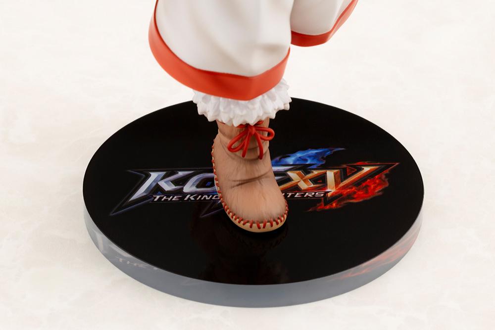 Close-up shot of Nakoruru's fur-trimmed boots and the printed The King of Fighters XV logo display base