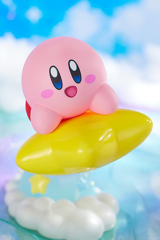 Close-up action angle of the Kirby figure soaring into the air, set against a bright, out-of-focus dream land cloud backdrop.