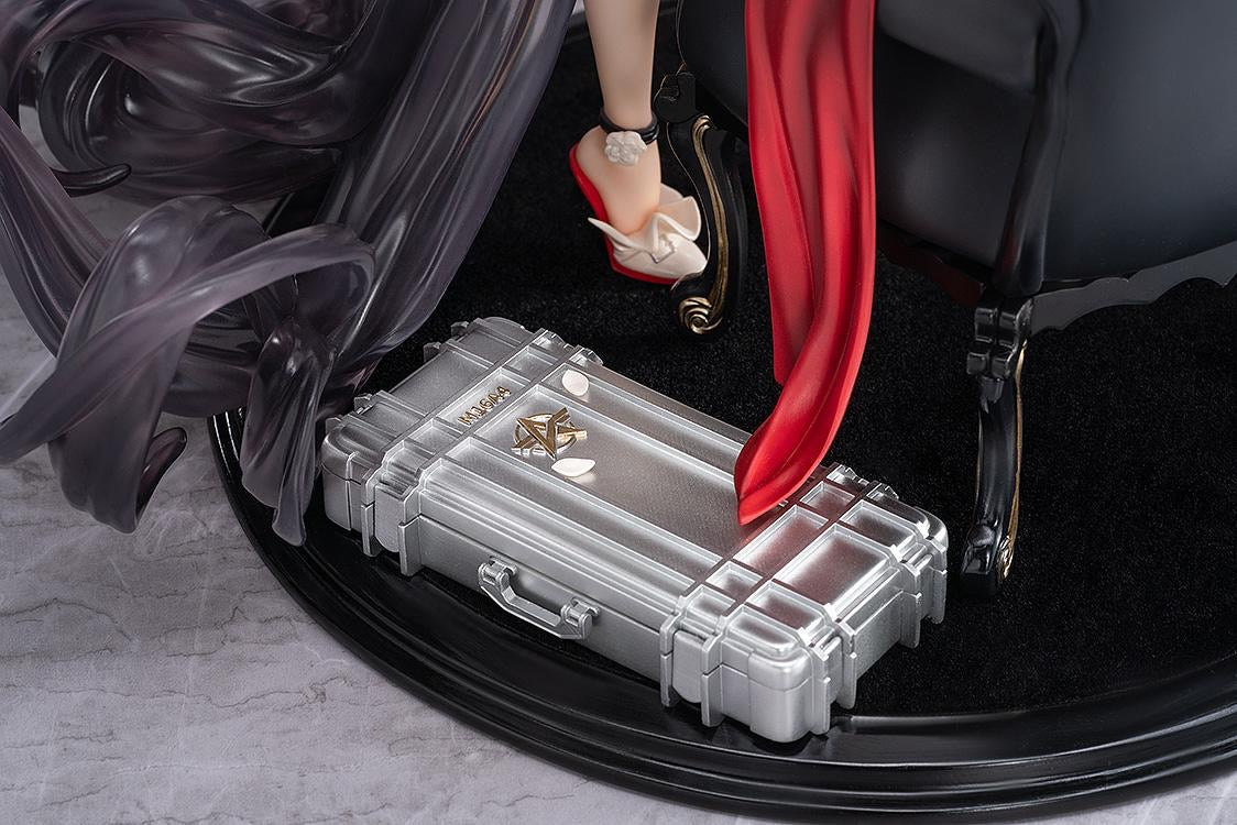 Detailed shot of the figure's base, showing the silver metallic gun case with the Knives Out logo and the base of the black velvet chair.