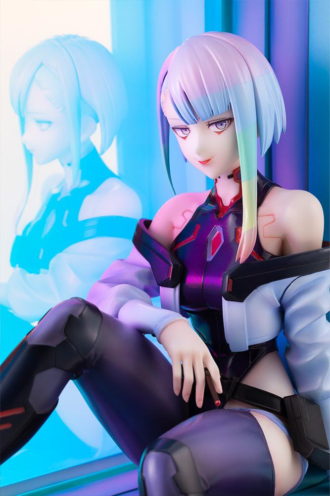 Close-up portrait of Lucy featuring rainbow hair and netrunner suit with her reflection cast on the glass panel.