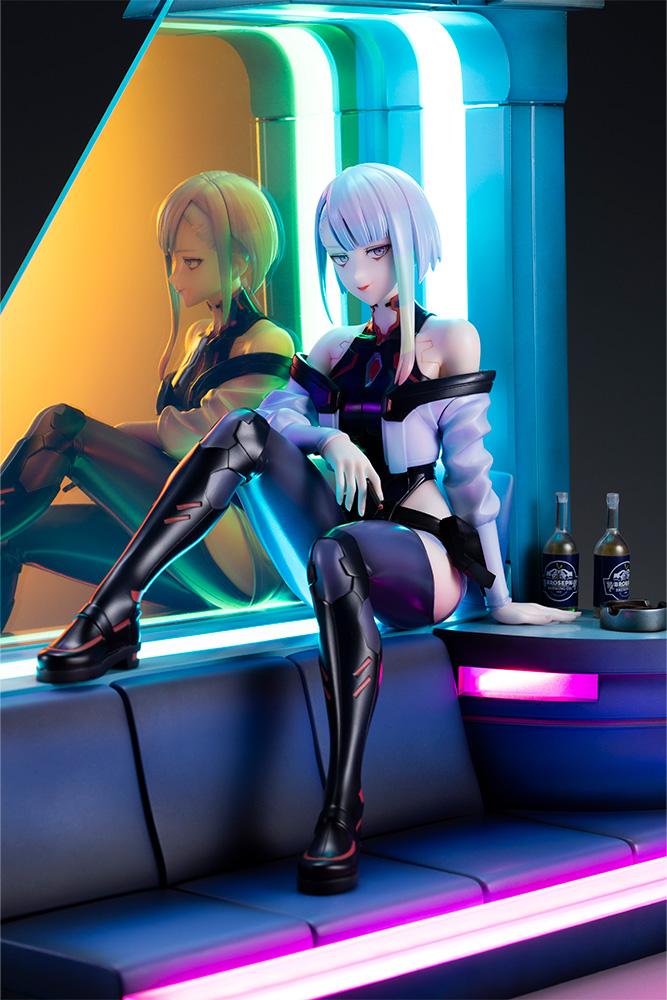 Front medium shot of Lucy seated on glowing sofa base with colorful neon reflection on Aurora panel.
