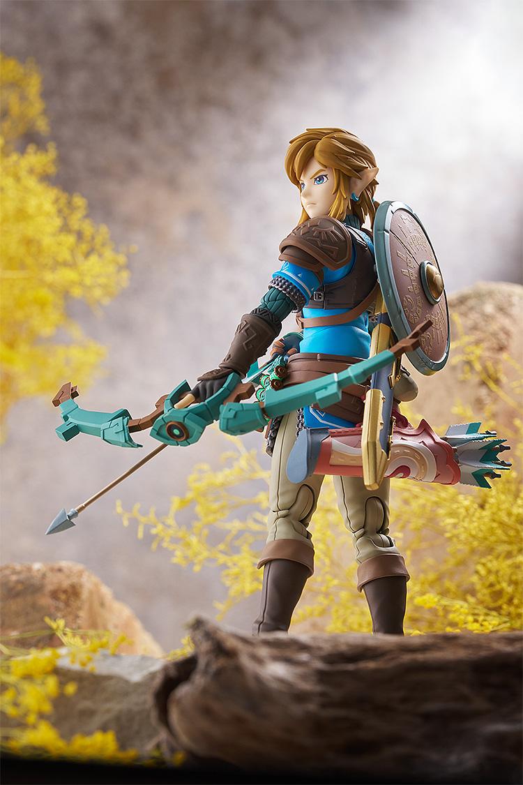 Rear view of Link figma holding the Construct Bow and wearing the Hylian Shield in a detailed landscape setting.