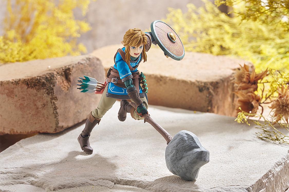 Action pose of figma Link swinging the Rock Hammer weapon accessory in a desert-like environment.