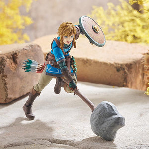 Action pose of figma Link swinging the Rock Hammer weapon accessory in a desert-like environment.