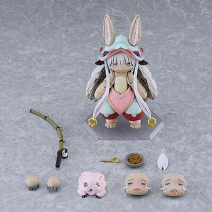 Overhead layout displaying the figma Nanachi action figure alongside all included box accessories, including extra face plates, hand parts, fishing rod, Mitty, and food bowl.