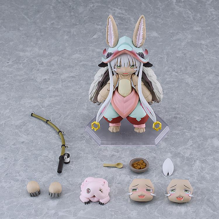 Overhead layout displaying the figma Nanachi action figure alongside all included box accessories, including extra face plates, hand parts, fishing rod, Mitty, and food bowl.