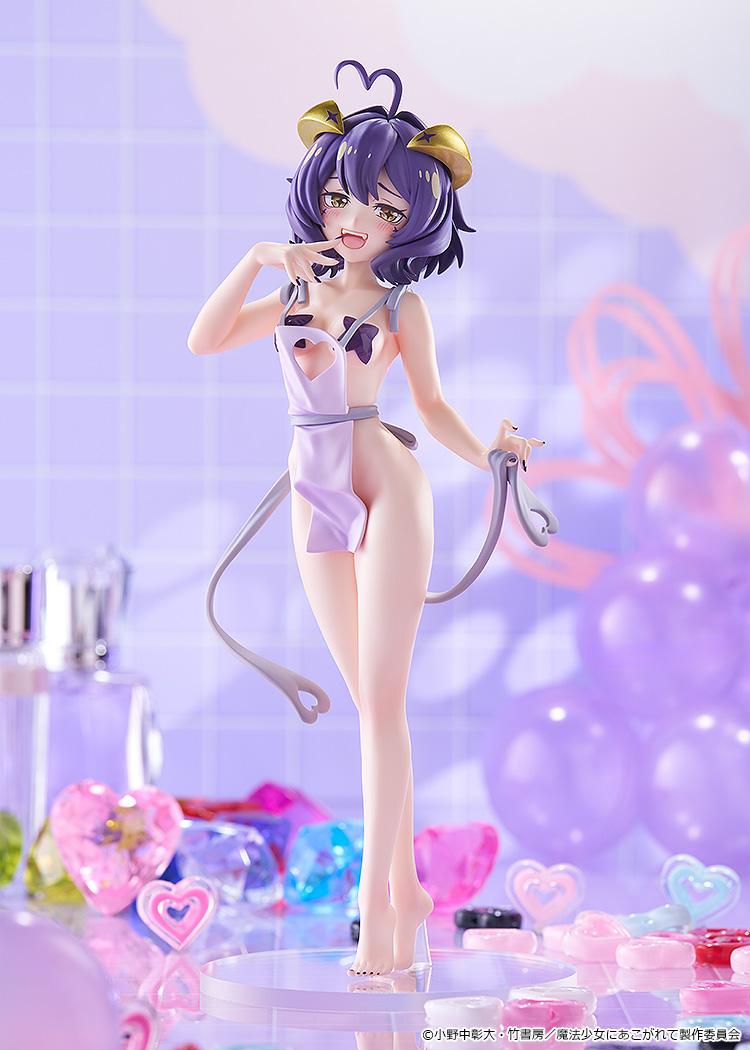 Full-body front shot of the Pop Up Parade L Magia Baiser Naked Apron Version figure displayed inside a pastel purple diorama backdrop with gems and decorations.