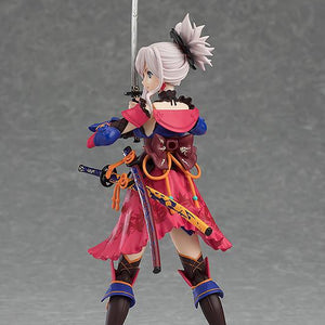 Rear profile of the Miyamoto Musashi figma figure, highlighting the swords, the vibrant colors of her costume, and her ponytail.