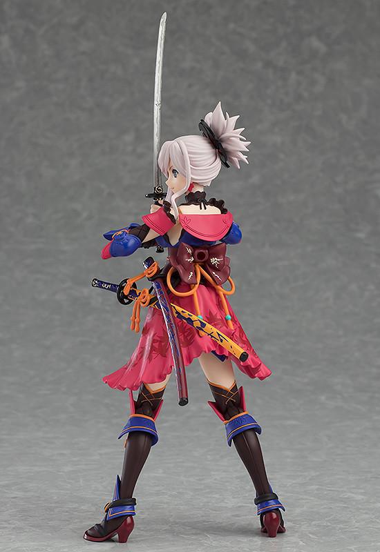 Rear profile of the Miyamoto Musashi figma figure, highlighting the swords, the vibrant colors of her costume, and her ponytail.