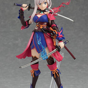 The Miyamoto Musashi figma figure in a ready stance, showing both swords and the vibrant blue and red energy effects unique to her figure.