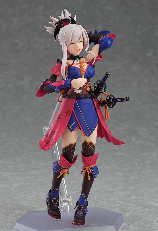 The Miyamoto Musashi figma figure with her delighted "smiling" face plate, holding and enjoying the included dango skewer accessory.