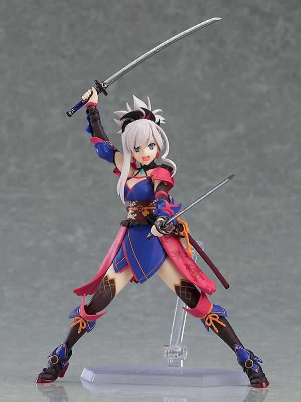 Miyamoto Musashi figma figure in a dynamic action pose, holding both katana swords above her head and smiling confidently.