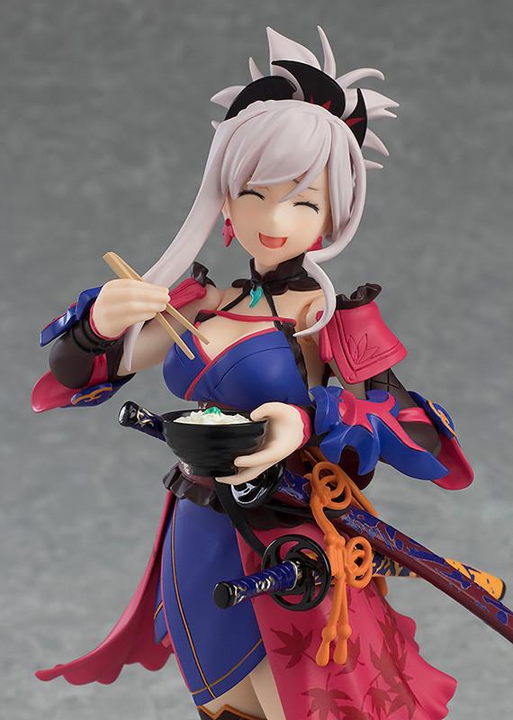A close-up of the Miyamoto Musashi figma figure, featuring her happy expression as she holds a bowl of udon with chopsticks.