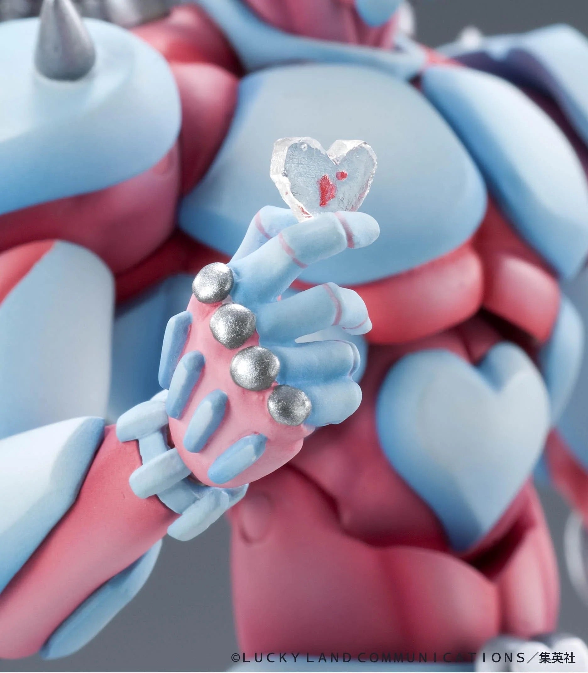 Close-up of the Crazy Diamond figure's hand, delicately holding the small, clear crystal heart accessory.