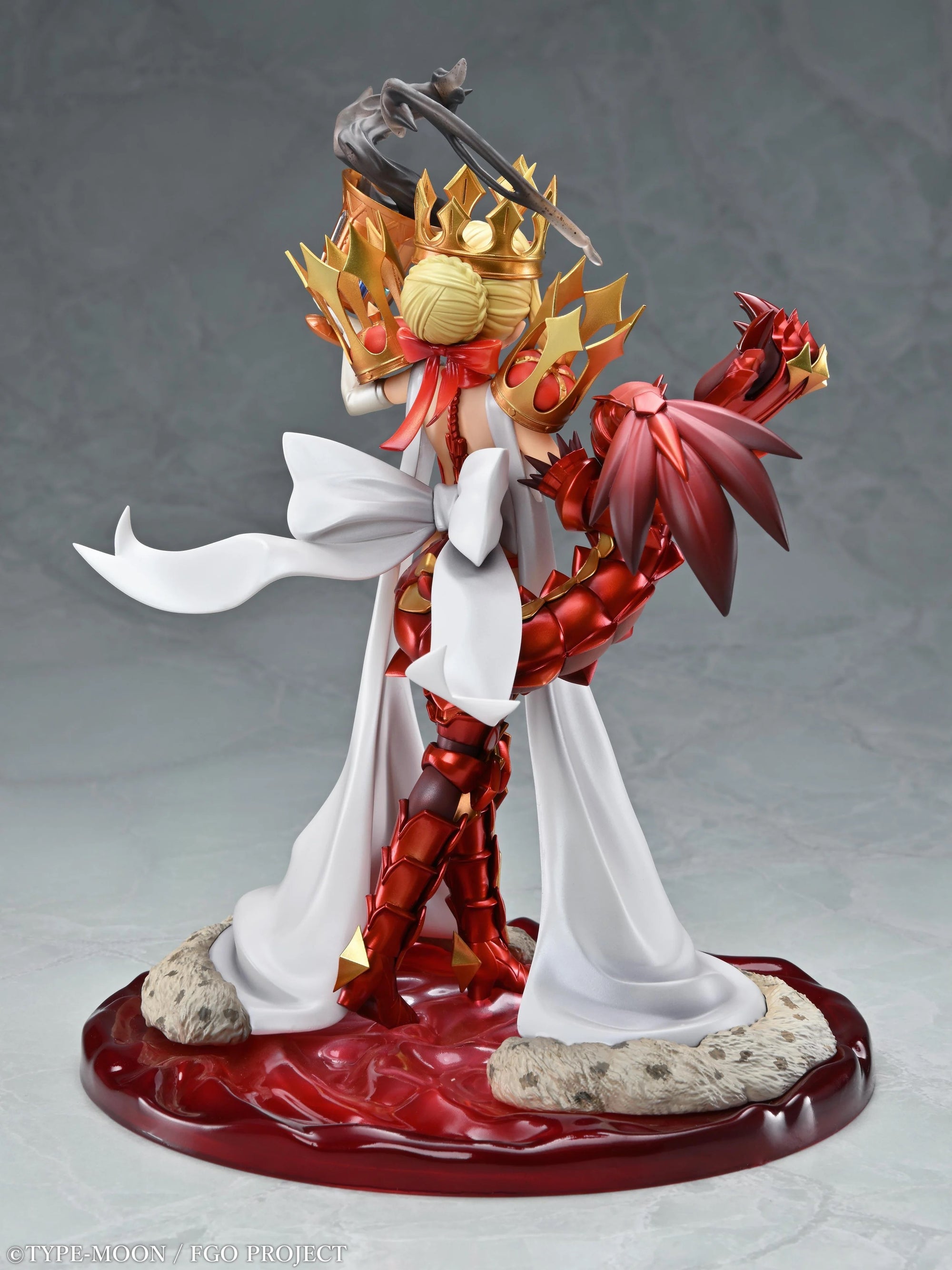Three-quarter back view of the Beast/Draco figure, emphasizing the red dragon-arm armor and the white ribbon trailing down the back.