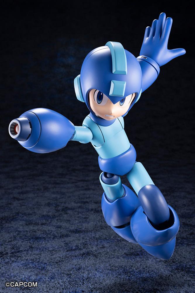 Mid-flight action jump pose of Mega Man firing the Mega Buster cannon forward with his left arm extended back.