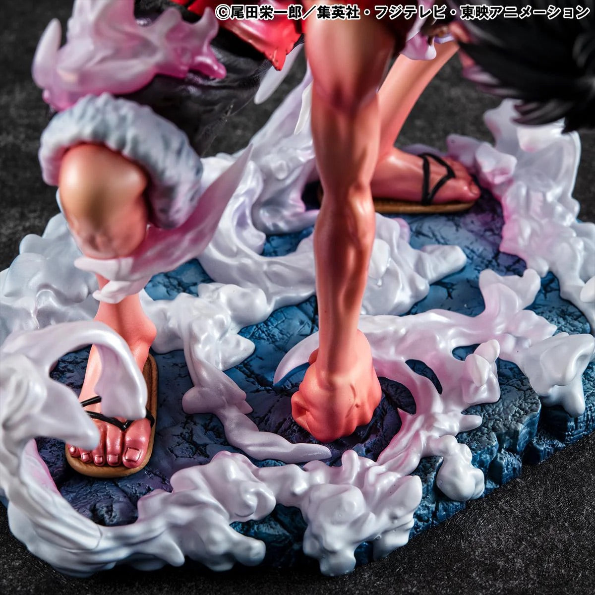 A close-up of the Luffy Gear 2 figure's bare feet and sandals, stepping onto the sculpted, cloudy steam base.