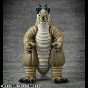Frontal view of the Transparent Kaiju figure, emphasizing the beige segmented body, green glowing eyes, and small horns.