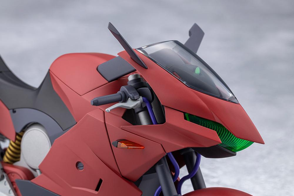 Close-up of the red sports bike front cowl featuring green clear visor headlight and handlebars.