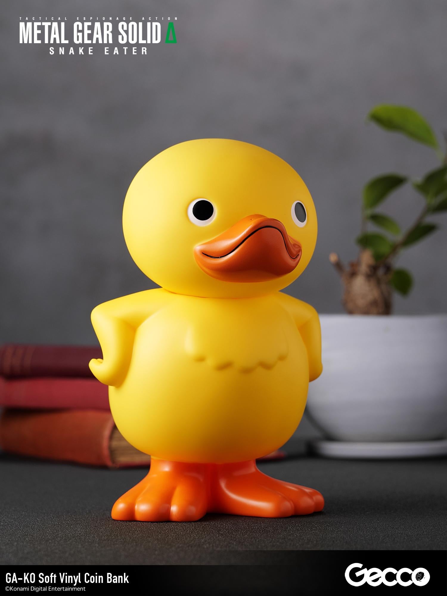 Three-quarter right angle shot of the GA-KO soft vinyl coin bank sitting on a desk alongside decor.