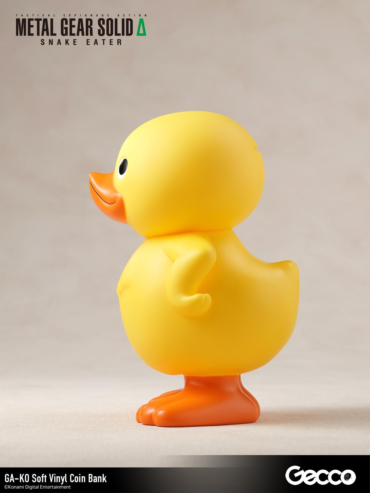 Left side profile view of the GA-KO yellow duck soft vinyl coin bank by Gecco.