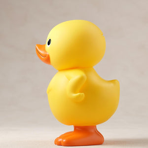 Left side profile view of the GA-KO yellow duck soft vinyl coin bank by Gecco.