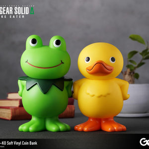 Kerotan green frog and GA-KO yellow duck soft vinyl coin banks displayed together on a decorated desk surface.