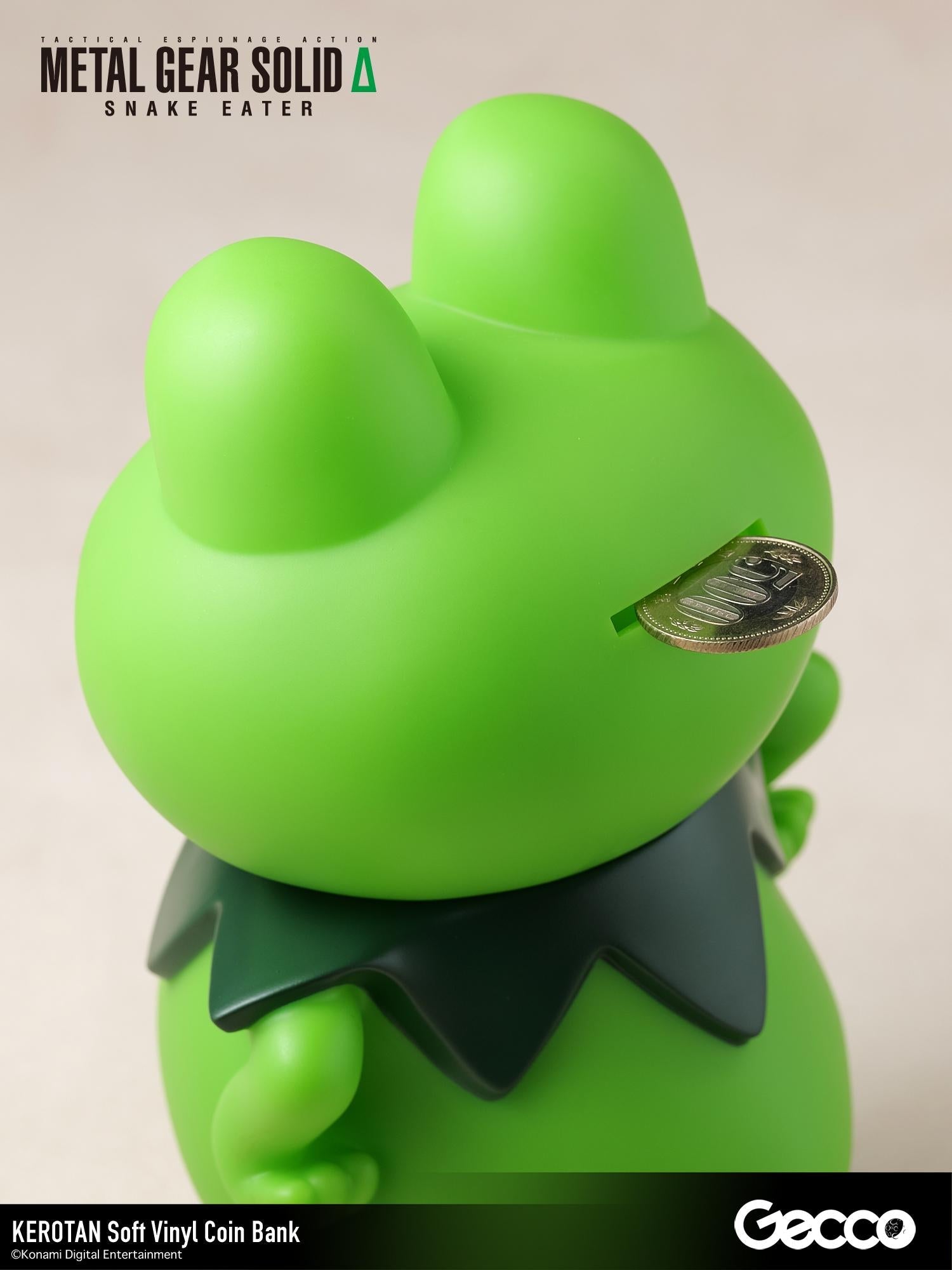 Close-up view of a coin being inserted into the slot on the back of the Kerotan vinyl coin bank.