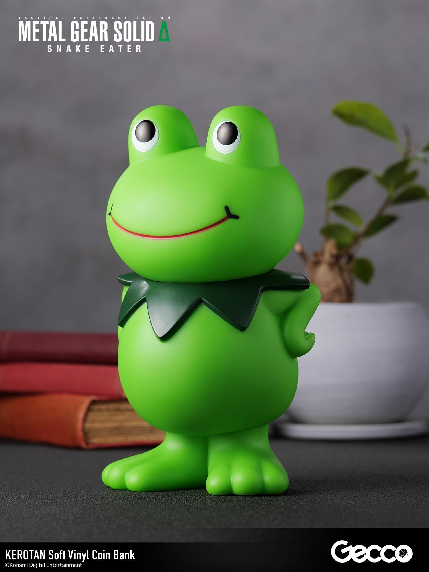 Three-quarter right angle shot of the Kerotan frog vinyl bank on a lifestyle desk setup.
