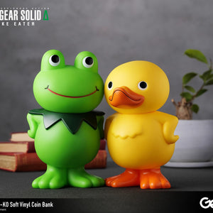 Close-up shot of the Kerotan frog and GA-KO duck vinyl coin banks posing side-by-side on a desk.