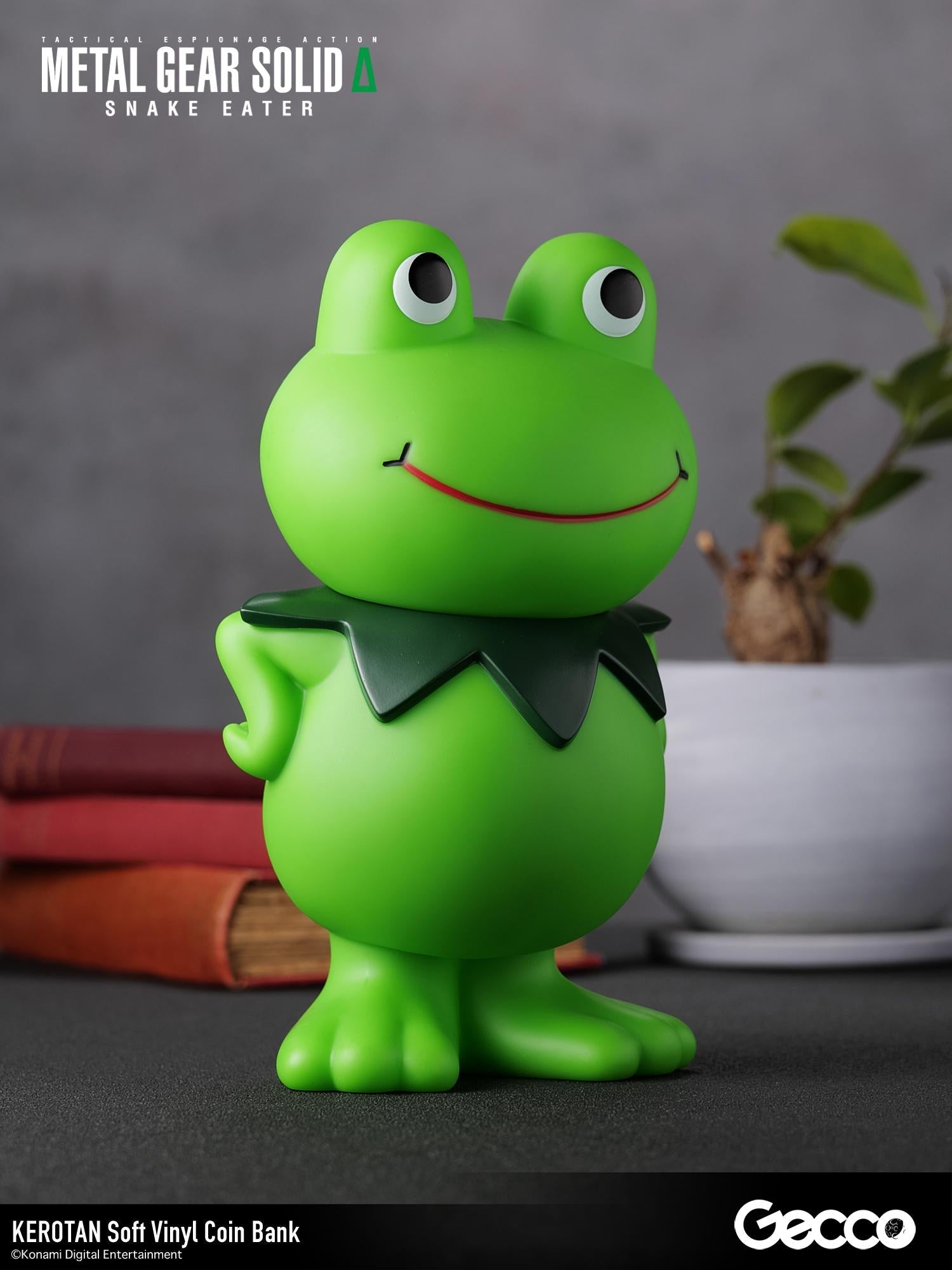 Three-quarter left angle shot of the Kerotan soft vinyl coin bank sitting on a desk alongside decor.
