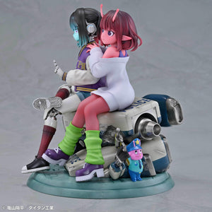 Side profile view of Makina leaning against Chiharu while sitting atop a retro futuristic police car base.