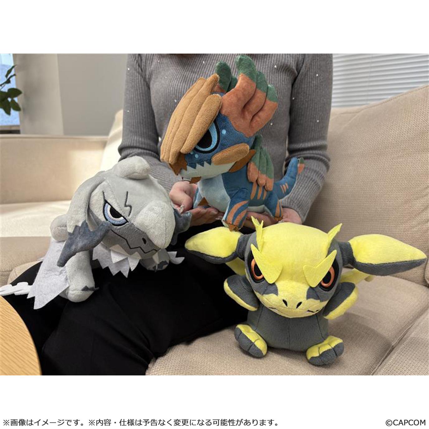 A group shot featuring the Jin Dahaad chibi plush alongside other Monster Hunter plushies, demonstrating its size as a perfect couch buddy.