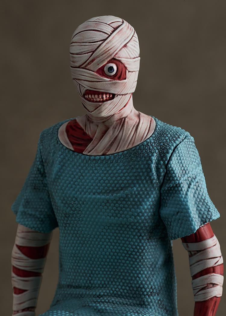 Detailed close-up portrait of Curly's bandaged head, exposed eye, smiling mouth, and textured blue hospital gown from the Mouthwashing video game figure.