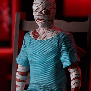 Medium close-up of Curly in the Swacchao! figure line sitting on a chair, highlighting upper body bandage details under red ambient lighting.