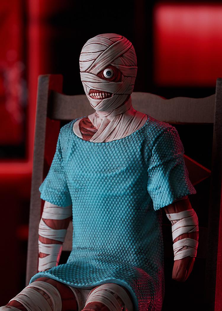 Medium close-up of Curly in the Swacchao! figure line sitting on a chair, highlighting upper body bandage details under red ambient lighting.