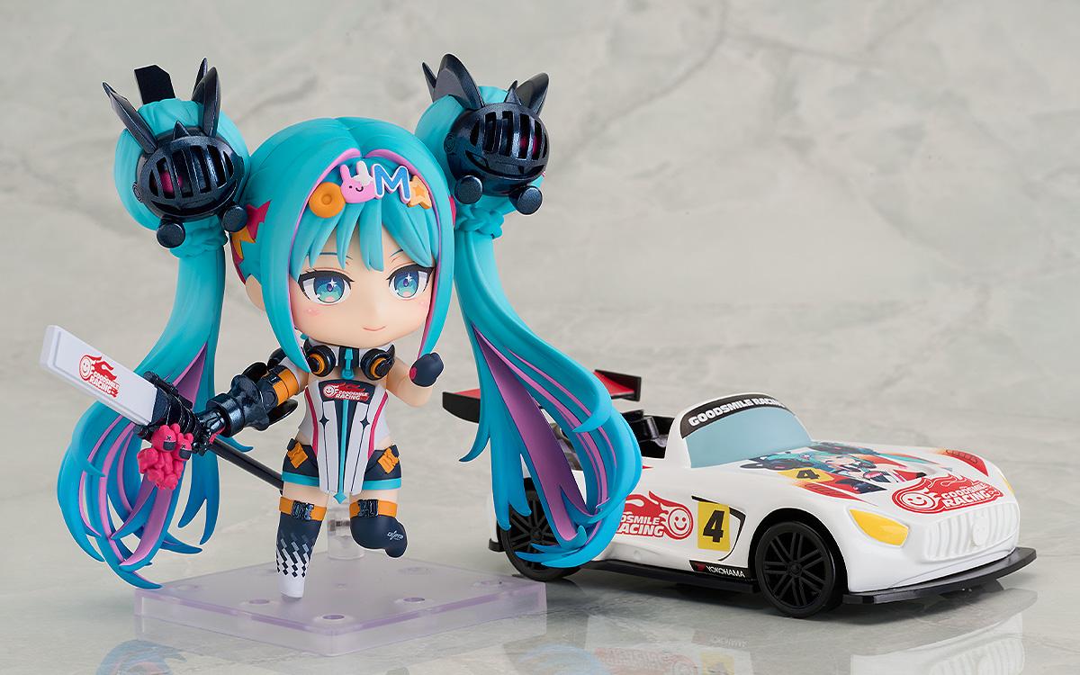 A back and side view of the Nendoroid Racing Miku: 2026 Ver. figure, displaying the detailed outfit design from the rear and the large articulated twin-tails.