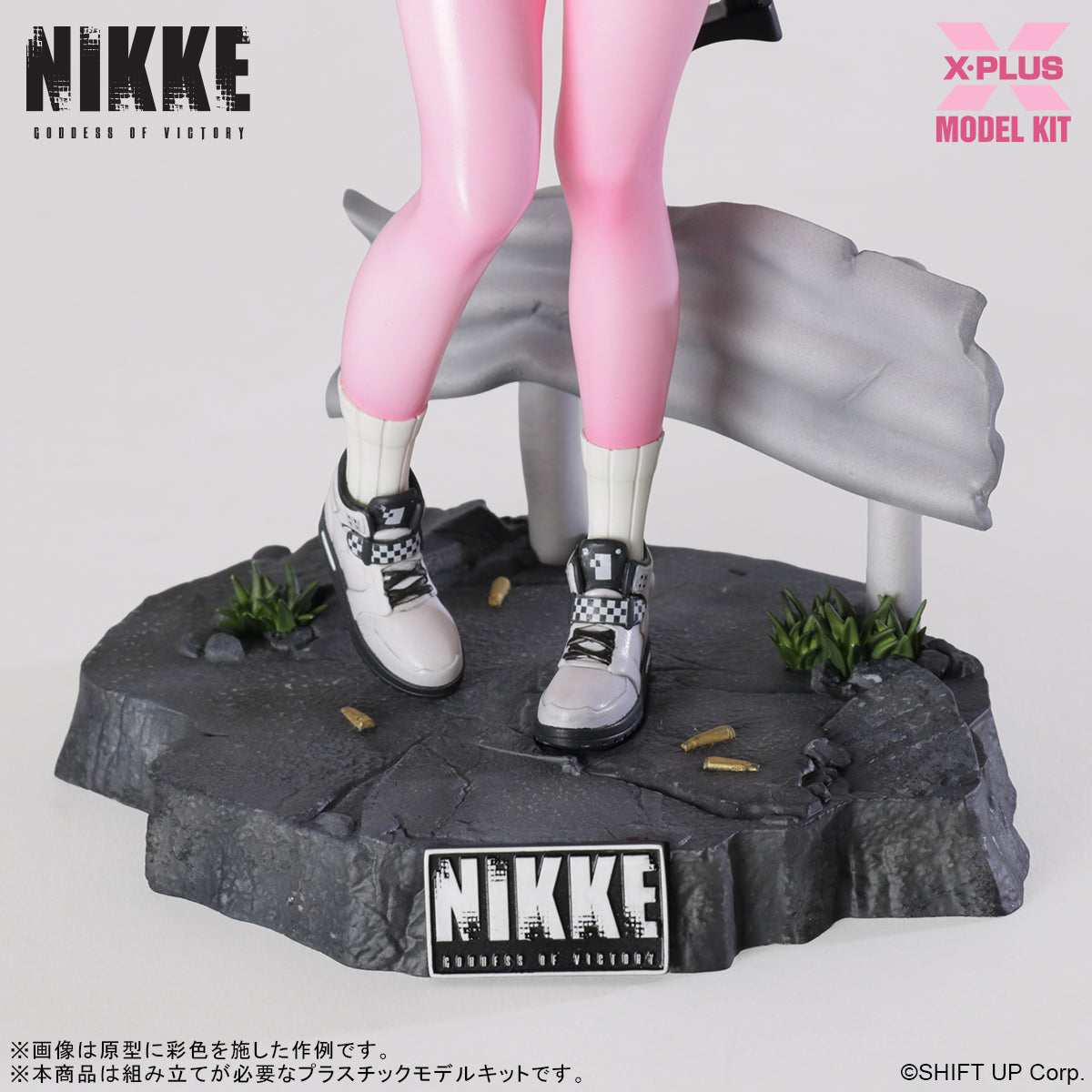 Detailed view of the Alice model kit's feet and sneakers on a cracked pavement base with spent bullet shells.