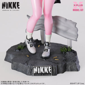 Detailed view of the Alice model kit's feet and sneakers on a cracked pavement base with spent bullet shells.